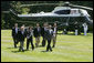 President George W. Bush leads his economic advisors past Marine One on the way to speak with reporters Friday, Aug. 18, 2006 in Camp David, Md., following their meeting on the nation’s economy. President Bush said the foundation of our economy is strong and is maintaining solid growth. White House photo by David Bohrer