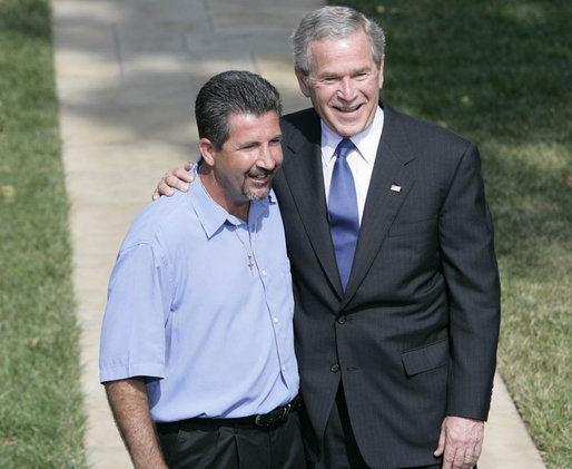 President George W. Bush smiles as he stands with Rockey Vaccarella during a statement to the media Wednesday, Aug. 23, 2006, on the White House lawn. Vaccarella, who lost his home in the wake of Hurricane Katrina and who drove to Washington D.C. to speak directly to the President, told reporters, "I just don't want the government and President Bush to forget about us," adding, "If we had this President for another four years, I think we'd be great." White House photo by Kimberlee Hewitt