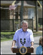 President George W. Bush smiles as he addresses his remarks to residents and state community leaders Monday, Aug. 28, 2006, following his walking tour through the Biloxi, Miss., neighborhood he visited following Hurricane Katrina in September 2005. The tour allowed President Bush the opportunity to assess the progress of the area’s recovery and rebuilding efforts a year after the devastating hurricane. White House photo by Eric Draper
