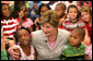 Mrs. Laura Bush embraces two students Monday, Aug. 28, 2006, as she meets and speaks with members of the Gorenflo Elementary School first grade class in their temporary portable classroom at the Beauvoir Elementary School in Biloxi, Miss. The students, whose school was damaged by Hurricane Katrina, are sharing the facilities of the Beauvoir school until their school’s renovations are complete. White House photo by Shealah Craighead
