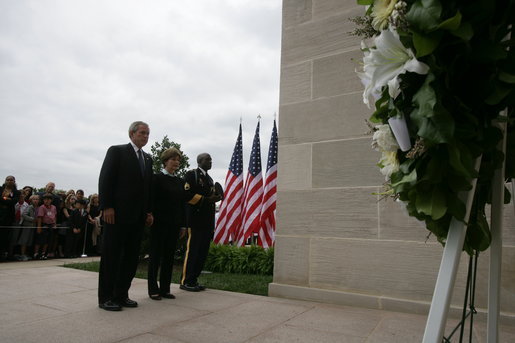 President George W. Bush and Laura Bush, accompanied by Sgt. Timothy Boyd of the Military District of Washington, stand before a memorial wreath Monday, Sept. 11, 2006, during a moment of silence at the Pentagon in Arlington, Va., to commemorate the fifth anniversary of Sept. 11, 2001 attacks. White House photo by Shealah Craighead