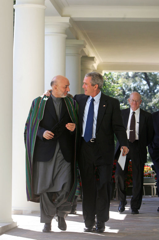 President George W. Bush walks with President Hamid Karzai of the Islamic Republic of Afghanistan along the colonnade in the Rose Garden Tuesday, Sept. 26, 2006. White House photo by David Bohrer