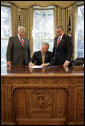 President George W. Bush signs S. 418, The Military Personnel Financial Services Protection Act, in the Oval Office Friday, Sept. 29, 2006. Standing with President Bush are bill sponsors Senator Mike Enzi, R-Wyo., left and Representative Geoff Davis, R-Ky. The legislation protects America’s armed forces by banning unscrupulous companies from military bases. It also prohibits the selling of life insurance products military personnel and their dependents unless specified written disclosures have been provided. White House photo by Eric Draper