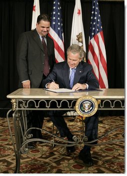 President George W. Bush signs S. 260, The Partners for Fish and Wildlife Act, in Stockton, Calif., Tuesday, Oct. 3, 2006. Pictured with President Bush is Congressman Richard Pombo, R-Ca. The legislation provides assistance to private landowners for voluntary projects to benefit federal trust species by promoting habitat improvement, restoration, enhancement, and establishment; and other public and private entities regarding fish and wildlife habitat restoration on private land.  White House photo by Eric Draper
