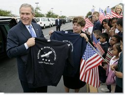 President George W. Bush holds up a T-shirt from George W. Bush Elementary School while visiting with students in Stockton, Calif., Tuesday, Oct. 3, 2006.  White House photo by Eric Draper