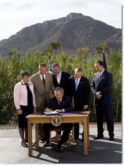 President George W. Bush is joined by Arizona legislators as he signs H.R. 5441, Department of Homeland Security Appropriations Act for fiscal year 2007, Wednesday, Oct. 4, 2006, against a backdrop of Camelback Mountain in Scottsdale. From left are: Arizona Gov. Janet Napolitano, Rep. J.D. Hayworth, Rep. Rick Renzi, Sen. Jon Kyl, R-Ariz., and Rep. Trent Franks. White House photo by Eric Draper
