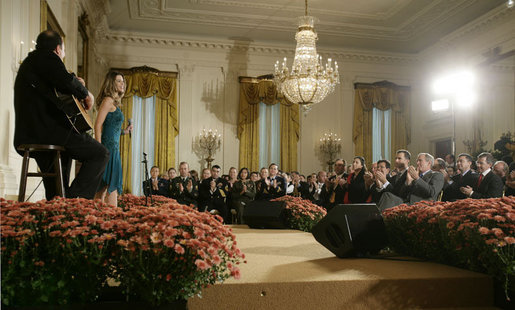 President George W. Bush is joined by Spain's Crown Prince Felipe de Borbon y Grecia, seated left, as they applaud the performance of singer Ana Cristina and guitarist Marco Linares, Friday, Oct. 6, 2006, in the East Room of the White House, in celebration of Hispanic Heritage Month. White House photo by Kimberlee Hewitt