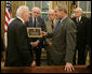 President George W. Bush is presented with a plaque at his meeting with members of the Supreme Headquarters Allied Expeditionary Force/Headquarters European Theater of Operations U.S. Army Veterans Association Friday, Oct. 6, 2006, in the Oval Office at White House. The group was organized in 1985 as a way to pay tribute to the memory of their supreme commander, Dwight D. Eisenhower, and their visit to the White House marks their 21st and final reunion gathering. White House photo by Paul Morse
