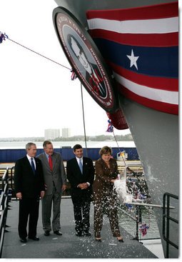 President George W. Bush joins his father, Former President George H. W. Bush and Northrop Grumman President Mike Petters, as his sister Doro Bush Koch breaks the bottle to christen the George H.W. Bush (CVN 77) in Newport News, Virginia, Saturday, Oct. 7, 2006.  White House photo by Eric Draper