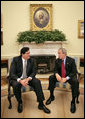 President George W. Bush talks with President Alan Garcia of Peru in the Oval Office Tuesday, Oct. 10, 2006. “We talked about world issues, we talked about issues regarding South America and Central America, and we talked about our bilateral relations,” said President Bush in his remarks to the press. “The central issue facing us right now is the passage of a free trade agreement.” White House photo by Eric Draper