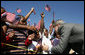 President George W. Bush greets flag-waving students at the Waldo C. Falkener Elementary School Wednesday, Oct. 18, 2006, in Greensboro, N.C., where he delivered remarks on the No Child Left Behind Act. White House photo by Paul Morse