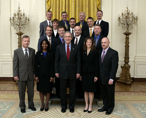 President George W. Bush stands with crew members of the Space Shuttle Discovery, the Space Shuttle Atlantis and the Space Station Expeditions 11, 12, and 13 Monday, Oct. 23, 2006, in the East Room of the White House. With the President in the front row, from left, are: Col. Steve Lindsey, Stephanie Wilson, Cmdr. Lisa Nowak, and Cmdr. Mark Kelly. Second row: Steven MacLean, Capt. Chris Ferguson, Col. Jeff Williams and Mike Fossum. Third row: Cmdr. Heidemarie Stefanyshyn-Piper, Cmdr. Dan Burbank and Dr. Piers Sellers. Top row: Capt. Brent Jett, Jr., Col. Bill McArthur, Jr., John Phillips and Joe Tanner. White House photo by Eric Draper