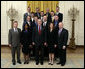 President George W. Bush stands with crew members of the Space Shuttle Discovery, the Space Shuttle Atlantis and the Space Station Expeditions 11, 12, and 13 Monday, Oct. 23, 2006, in the East Room of the White House. With the President in the front row, from left, are: Col. Steve Lindsey, Stephanie Wilson, Cmdr. Lisa Nowak, and Cmdr. Mark Kelly. Second row: Steven MacLean, Capt. Chris Ferguson, Col. Jeff Williams and Mike Fossum. Third row: Cmdr. Heidemarie Stefanyshyn-Piper, Cmdr. Dan Burbank and Dr. Piers Sellers. Top row: Capt. Brent Jett, Jr., Col. Bill McArthur, Jr., John Phillips and Joe Tanner. White House photo by Eric Draper