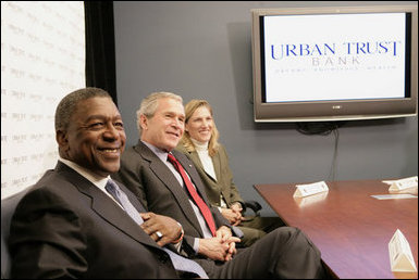 President George W. Bush sits with Bob Johnson, founder and chairman of the RLJ Companies, and Kathy Boden, right, president and CEO of Blue House Water Solutions , during a meeting to discuss the economy with small business owners and community bankers, Monday, Oct. 23, 2006 at the Urban Trust Bank in Washington, D.C. White House photo by Eric Draper