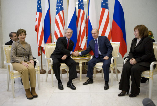 President George W. Bush and Russia's President Vladimir Putin exchange handshakes Wednesday, Nov. 15, 2006, as Mrs. Laura Bush and Lyudmila Putina look on. The brief Moscow stop was the first on the President and First Lady's week-long trip. White House photo by Eric Draper