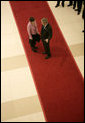 President George W. Bush confers with Prime Minister Helen Clark of New Zealand as he departs the National Conference Center following Saturday's first session of the 2006 APEC Summit in Hanoi. White House photo by Eric Draper