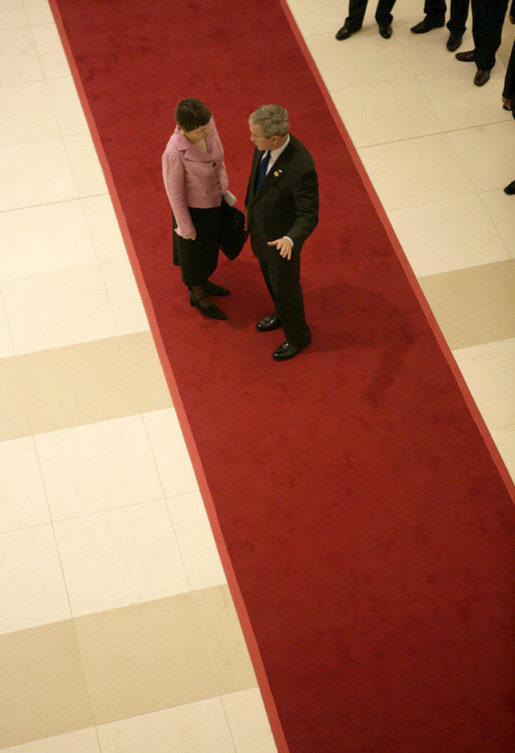President George W. Bush confers with Prime Minister Helen Clark of New Zealand as he departs the National Conference Center following Saturday's first session of the 2006 APEC Summit in Hanoi. White House photo by Eric Draper