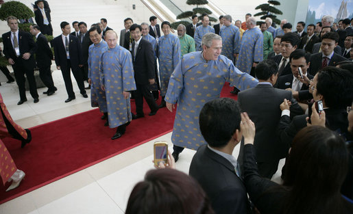 President George W. Bush reaches out to an onlooker as the leaders of the 2006 Asia-Pacific Economic Cooperation parade to APEC Island for their official portrait Sunday, Nov. 19, 2006, in Hanoi. White House photo by Eric Draper