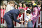 President George W. Bush and Mrs. Laura Bush pause to greet a young boy as they leave church services Sunday, Nov. 19, 2006, at the Cua Bac Church in Hanoi. White House photo by Shealah Craighead