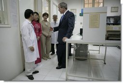 President George W. Bush and Mrs. Laura Bush are briefed as they tour the Pasteur Institute in Ho Chi Minh City Monday, Nov. 20, 2006.  