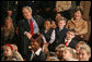 President George W. Bush and Mrs. Laura Bush sit with children of deployed U.S. military personnel and watch a performance of "Willy Wonka" by members of The Kennedy Center Education Department in the East Room Monday, Dec. 4, 2006. White House photo by Eric Draper
