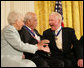 Author Paul Johnson is congratulated by Dr. Norman C. Francis and Ruth Johnson Colvin after receiving his Presidential Medal of Freedom from President George W. Bush Friday, Dec. 15, 2006, during ceremonies in the East Room of the White House. In honoring Mr. Johnson, President Bush said, "Our country honors Paul Johnson, and proudly calls him a friend." White House photo by Shealah Craighead