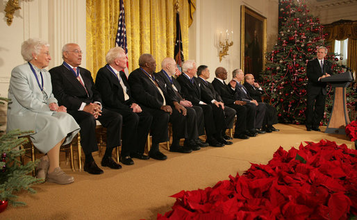 President George W. Bush looks back as he addresses the 2006 recipients of the Presidential Medal of Freedom on stage in the East Room of the White House Friday, Dec. 15, 2006. Said the President, "The Presidential Medal of Freedom is our nation's highest civil honor. The medal recognizes high achievement in public service, science, the arts, education, athletics, and other fields. Today we honor 10 exceptional individuals who have gained great admiration and respect throughout our country." White House photo by Shealah Craighead