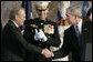 President George W. Bush and Secretary of Defense Donald Rumsfeld shake hands following President Bush's remarks honoring outgoing Secretary Rumsfeld during an Armed Forces Full Honor Review at the Pentagon Friday, Dec. 15, 2006, as Joint Chiefs of Staff Chairman General Peter Pace applauds. White House photo by Paul Morse