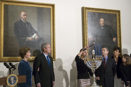 President George W. Bush and Laura Bush watch as Ariel Cohen, 14, lights the Menorah on the fourth night of Hanukkah during the annual White House Hanukkah reception Monday, Dec. 18, 2006. Pictured at right are Ariel's parents, Dan and Rachel Cohen, and sister Alison, 11. White House photo by Shealah Craighead