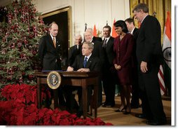 President George W. Bush is joined by U.S. Secretary of State Condoleezza Rice and U.S. legislators, as he signs H.R. 5682 The United States-India Peaceful Atomic Cooperation Act, Monday, Dec. 18, 2006, in the East Room of the White House. H.R. 5682 will allow the U.S. and India to share civilian nuclear technology and bring India’s civilian nuclear program under the safeguards of the International Atomic Energy Agency.  White House photo by Eric Draper