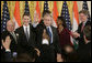 President George W. Bush acknowledges the applause of invited guests after signing H.R. 5682 The United States-India Peaceful Atomic Cooperation Act, Monday, Dec. 18, 2006, in the East Room of the White House. H.R. 5682 will allow the U.S. and India to share civilian nuclear technology and bring India’s civilian nuclear program under the safeguards of the International Atomic Energy Agency. White House photo by Kimberlee Hewitt