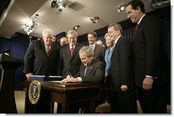 President George W. Bush signs H.R. 6111, the Tax Relief and Health Care Act of 2006, in the Dwight D. Eisenhower Executive Office Building, Dec. 20, 2006. Pictured with the President are, from left: Speaker Dennis Hastert, Sen. Bill Frist, R-Tenn., obscured, Sen. Pete Domenici, R-N.M., obscured, Rep. Bill Thomas, R-Calif., Sen. David Vitter, R-La., Secretary of the Interior, Dirk Kempthorne, obscured, Sen. Mary Landrieu, D-La., Sen. Mike DeWine, R-Ohio and Sen. Rick Santorum, R-Pa.  White House photo by Kimberlee Hewitt