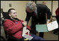 President George W. Bush congratulates Pvt. First Class Tony Brawdy of Tulsa, OK., after presenting him with two Purple Hearts Friday, Dec. 22, 2006, during a visit to Walter Reed Army Medical Center, where the soldier is recovering from injuries suffered in Operation Iraqi Freedom. White House photo by Eric Draper