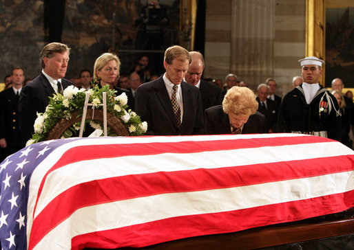 Former first lady Betty Ford kneels at the casket of her husband, former President Gerald R. Ford, in the U.S. Capitol rotunda during the State Funeral ceremony, Saturday, December 30, 2006. Accompanying Mrs. Ford are her children, from left, John G. Ford, Susan Ford Bales, Michael Ford and Steven Ford. White House photo by David Bohrer