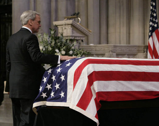 Newsman Tom Brokaw places his hand on the casket of former President Gerald W. Ford, as he makes his way to the lectern to deliver his remarks during the State Funeral service Tuesday, Jan. 2, 2007, at the National Cathedral in Washington, D.C. White House photo by Eric Draper