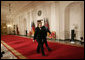 President George W. Bush and German Chancellor Angela Merkel leave Cross Hall at the White House, Thursday evening, Jan. 4, 2006, following their joint news conference. White House photo by Eric Draper