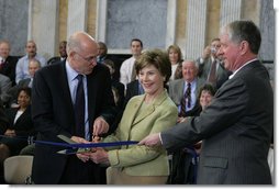 Mrs. Laura Bush is joined by U.S. Secretary of the Treasury Henry M. Paulson, Jr., left, and Richard C. Cote, curator, U.S. Department of the Treasury, as she cuts the ceremonial ribbon to mark the completion of the first major restoration at the U.S. Treasury Building, Thursday, Jan. 11, 2007, in Washington, D.C.  White House photo by Shealah Craighead