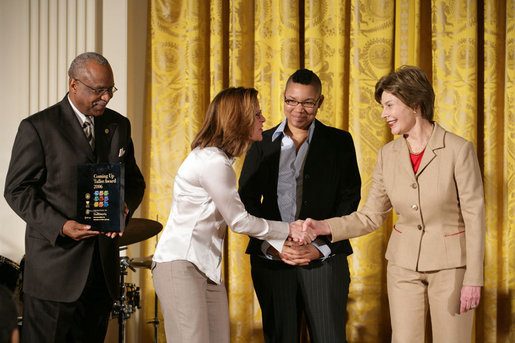 Mrs. Laura Bush presents Michelle Butler, left, and Alisa Lemon, center, of Studioworks, part of Communities in Schools in New Jersey, a Coming Up Taller Award during a ceremony in the East Room Monday, Jan. 22, 2007. James Farmer of PCAH is pictured at the far left. Each year, the Coming Up Taller Awards recognize and reward excellence in community arts and humanities programs for underserved children and youth. White House photo by Shealah Craighead