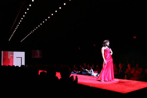 Mrs. Laura Bush and Joyce Cullen, a heart disease survivor, watch Angela Bassett model a red dress by Carmen Marc Valvo during the Red Dress Collection Celebrity Fashion Show at Bryant Park in New York, Friday, Feb. 2, 2007. White House photo by Shealah Craighead