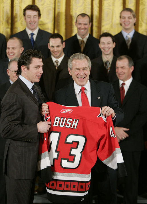 President George W. Bush receives a personalized team sweater from the Carolina Hurricane's team captain, Rod Brind'Amour, as the team was honored Friday, Feb. 2, 2007, at the White House for winning the 2006 Stanley Cup. White House photo by Paul Morse