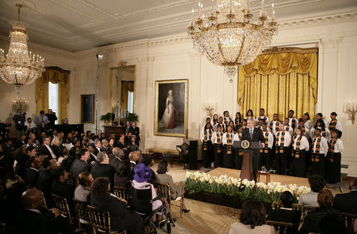 President George W. Bush, standing with members of the Jackson High School Black History Tour Group of Jackson, Mich., welcomes guests to the East Room of the White House, Monday, Feb. 12, 2007, during the celebration of African American History Month. White House photo by Eric Draper