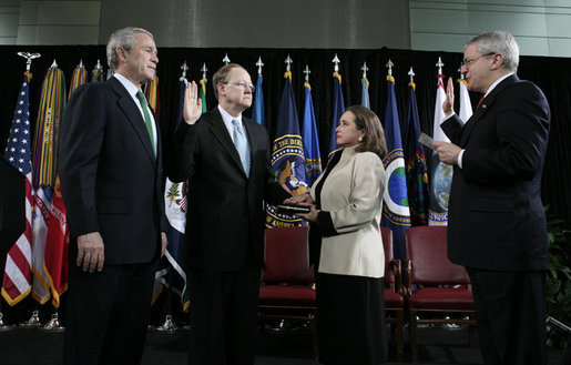 President George W. Bush stands with Director of National Intelligence J. Michael “Mike” McConnell during his ceremonial swearing-in Tuesday, Feb. 20, 2007 at Bolling Air Force Base in Washington, D.C., taking his oath from White House Chief of Staff Josh Bolten, as McConnell’s wife, Terry, holds the Bible. White House photo by Paul Morse