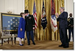 President George W, Bush applauds as Medal of Honor recipient U.S. Army Major Bruce P. Crandall kisses his wife, Arlene, in the East Room of the White House, Monday, Feb. 26, 2007. Crandall was awarded the Medal of Honor for his extraordinary heroism as a 1st Cavalry helicopter flight commander in the Republic of Vietnam in November 1965. White House photo by Eric Draper
