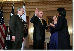 President George W. Bush looks on as Secretary of State Condoleezza Rice administers the oath of office to Deputy Secretary of State John Negroponte Tuesday, Feb. 27, 2007, in the Benjamin Franklin Room at the U.S. Department of State. Holding the Bible for the ceremonial swearing-in is Dr. Diana Negroponte, wife of Secretary Negroponte.  White House photo by Paul Morse
