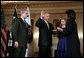 President George W. Bush looks on as Secretary of State Condoleezza Rice administers the oath of office to Deputy Secretary of State John Negroponte Tuesday, Feb. 27, 2007, in the Benjamin Franklin Room at the U.S. Department of State. Holding the Bible for the ceremonial swearing-in is Dr. Diana Negroponte, wife of Secretary Negroponte. White House photo by Paul Morse