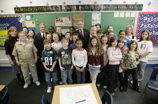 President George W. Bush is joined by Indiana Gov. Mitch Daniels, center, and Indiana Congressman Baron Hill, at left, as they pose for a photo with students and teachers Teri Sanders and Tammy Persinger in the fifth grade U.S. History class at the Silver Street Elementary School in New Albany, Ind., Friday, March 2, 2007. White House photo by Eric Draper