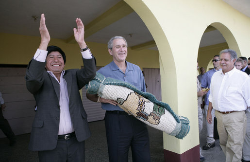 President George W. Bush holds a gift from Mayor Raymundo Juarez during a visit Monday, March 12, 2007, to Santa Cruz Balanya, Guatemala. Pictured at right is Guatemalan President Oscar Berger. White House photo by Eric Draper