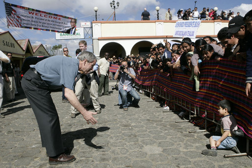 President George W. Bush tries to coax a shy young boy from the crowd Monday, March 12, 2007, during his visit with Mrs. Laura Bush to Santa Cruz Balanya, Guatemala. White House photo by Eric Draper