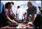 President George W. Bush talks with a vendor in the Town Square of Santa Cruz Balanya Monday, March 12, 2007, during a tour of the Guatemalan village. White House photo by Paul Morse