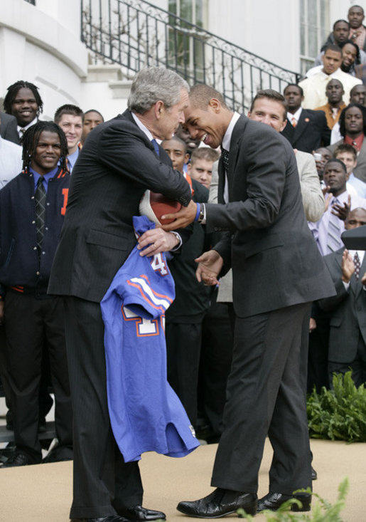 President George W. Bush takes a hand off of a game ball from University of Florida Gators quarterback Chris Leak, during ceremonies Monday, March 19, 2007 on the South Lawn of the White House, to honor the 2006 NCAA football championship team. White House photo by Eric Draper